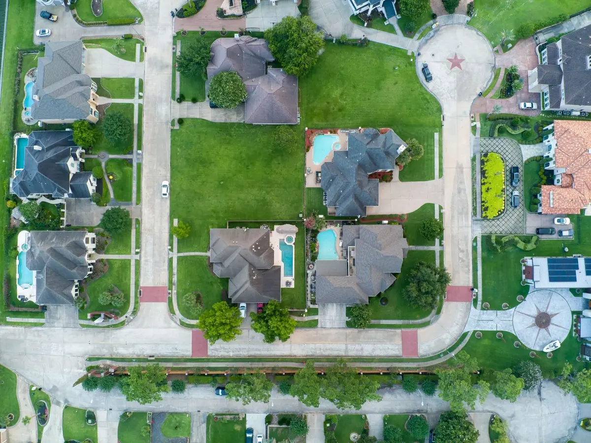 Aerial drone view of a suburban Texas neighborhood with houses and pools (representative stock photo, not this specific area)