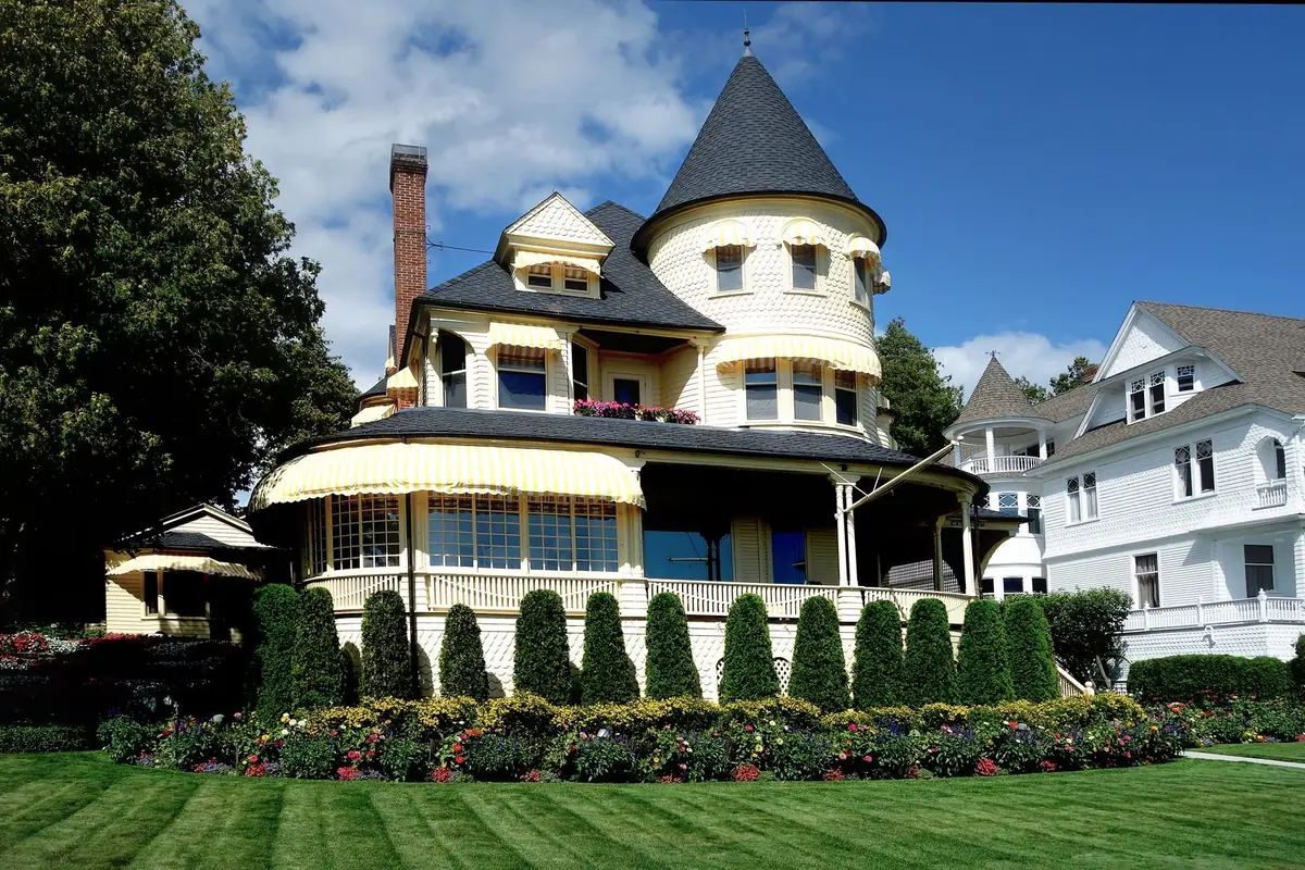 A Victorian-style historic home with a wraparound porch (representative stock photo, not this specific area)